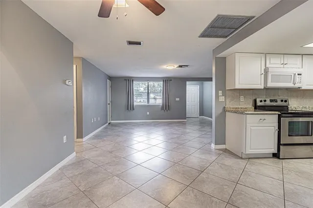 a view of an empty room and kitchen view