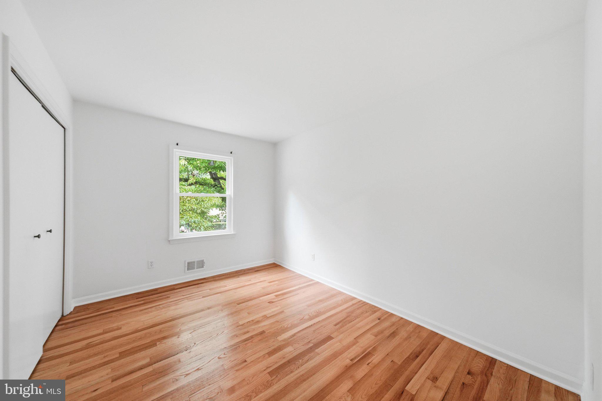 13120 Clifton Road Silver Spring, MD 20904 - Photo 41 of 69 a view of an empty room with wooden floor and a window