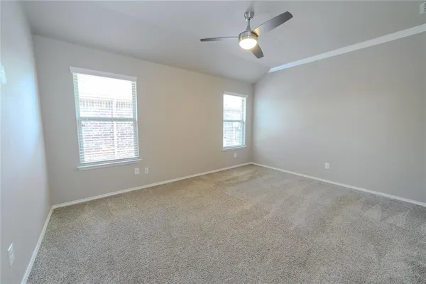 a view of empty room with windows and chandelier fan