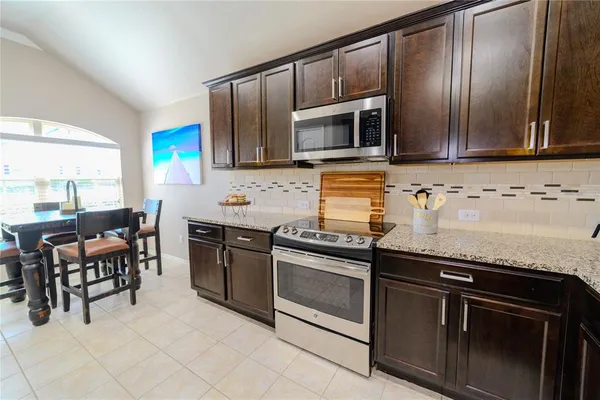 a kitchen with stainless steel appliances granite countertop a stove microwave and sink
