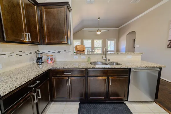 a kitchen with granite countertop a sink stove and cabinets