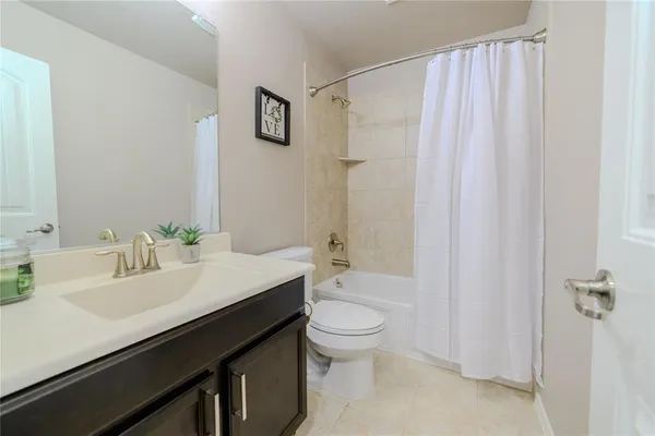 a bathroom with a sink a toilet a mirror and shower