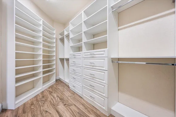 a view of walk in closet with empty racks