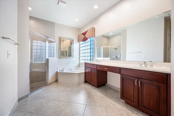a spacious bathroom with a bathtub sink and mirror