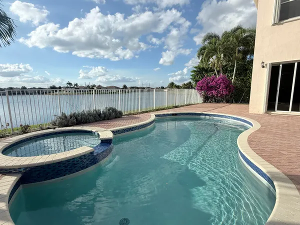 a view of a backyard with swimming pool and seating space