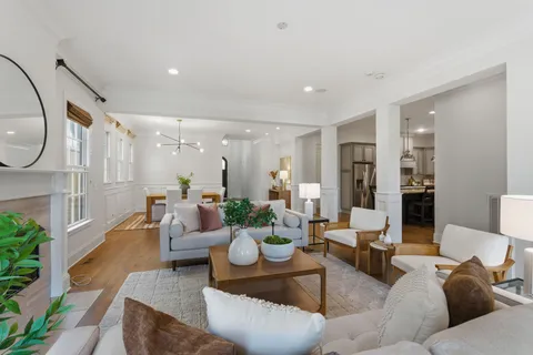 a living room with furniture and a chandelier