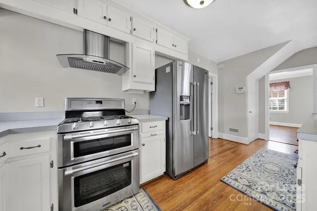 a kitchen with stainless steel appliances a stove a refrigerator and cabinets