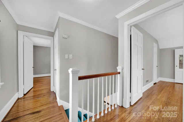 a view of a hallway with wooden floor and staircase