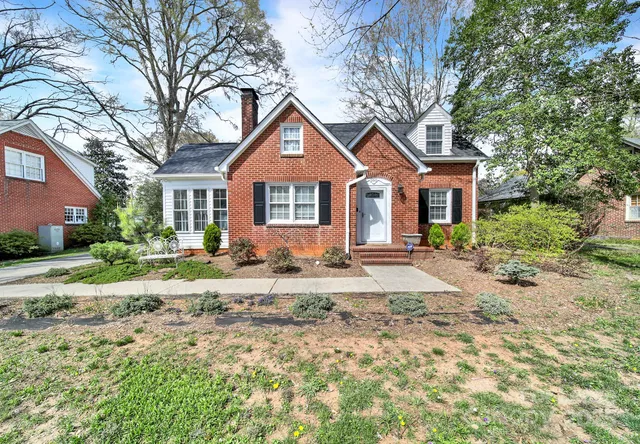 a front view of a house with a yard and trees