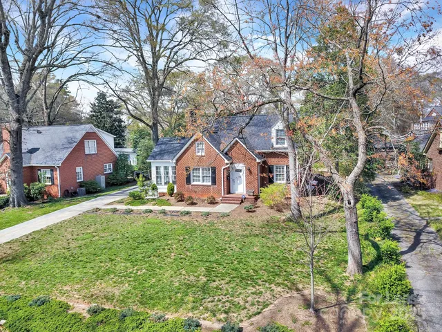 a front view of a house with yard and green space