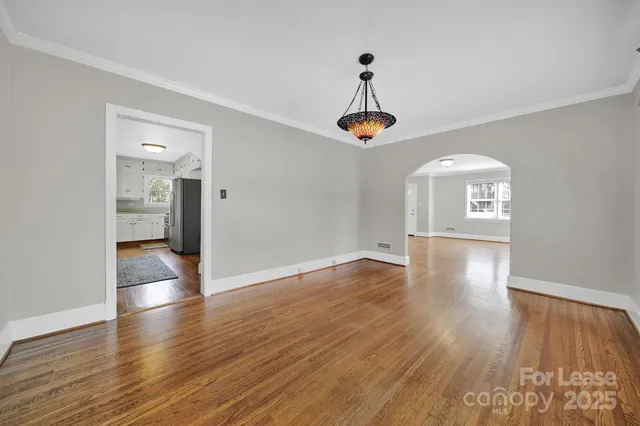 a view of empty room with wooden floor and window