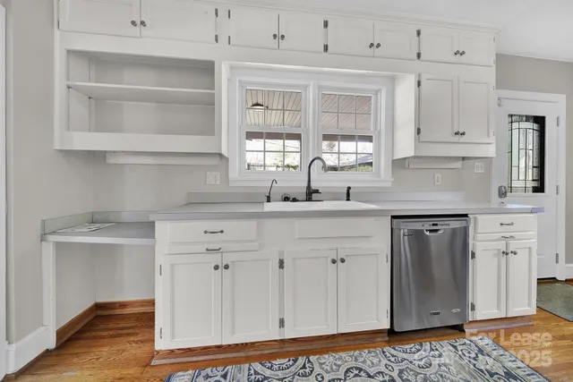 a kitchen with white cabinets and sink
