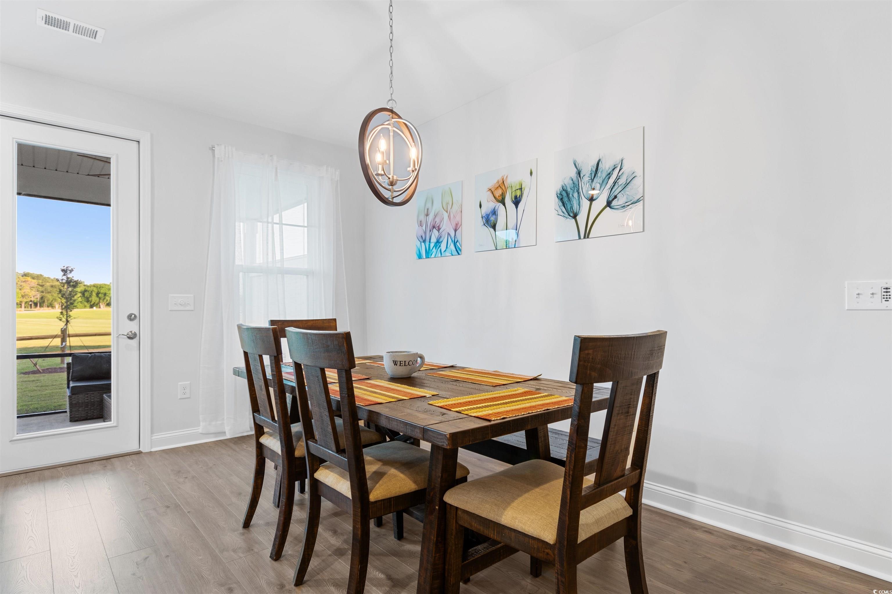 5117 Double Eagle Way North Myrtle Beach, SC 29582 - Photo 6 of 20 Dining area featuring wood finished floors and a chandelier