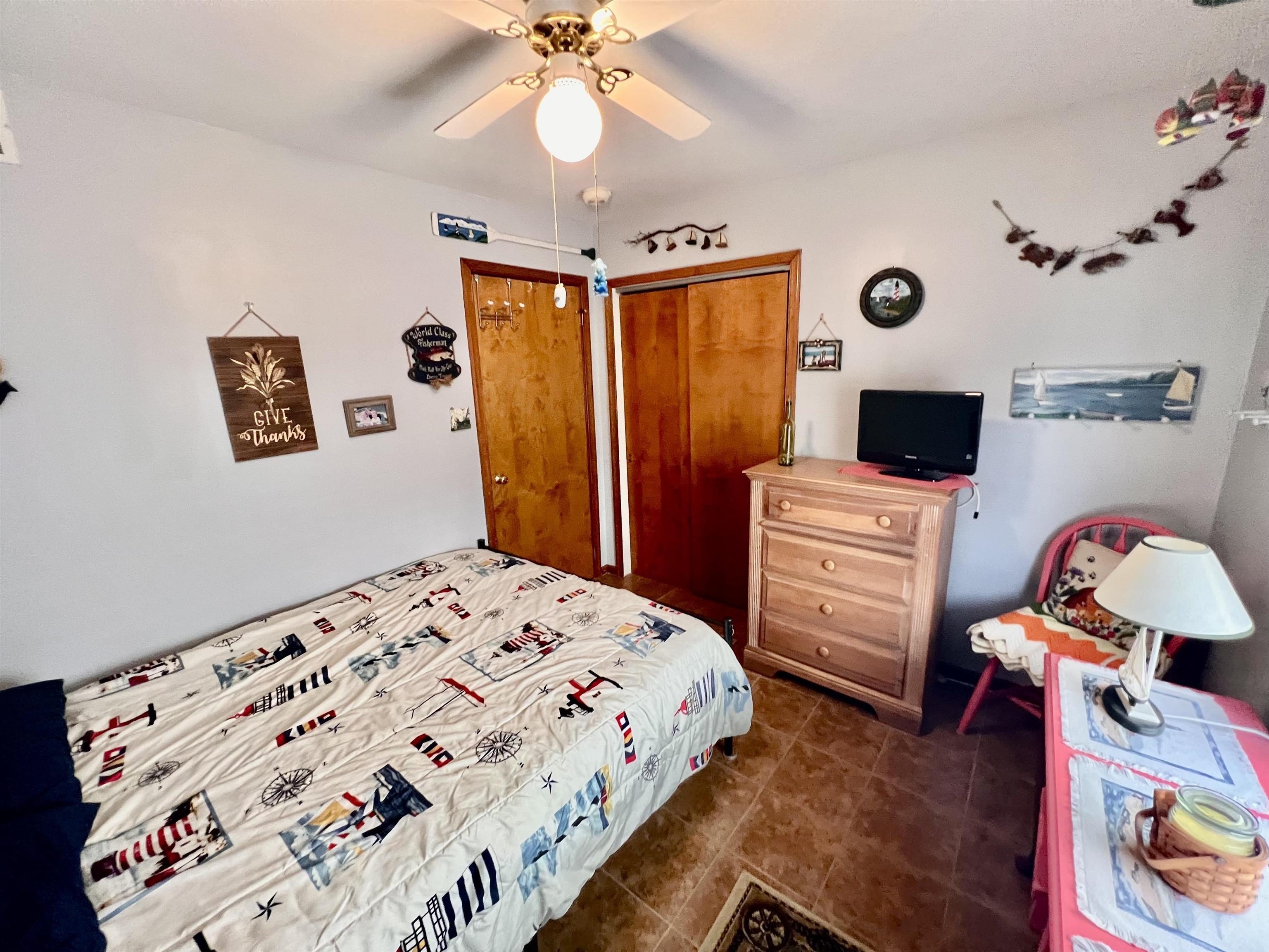 532 West Anglesea Drive, Unit A North Wildwood, NJ 08260 - Photo 13 of 28 a bedroom with a bed and a chandelier