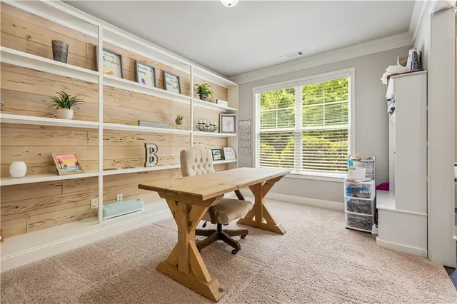a view of a workspace with furniture and a window