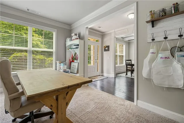 a view of a livingroom and a dining room with wooden floor and windows