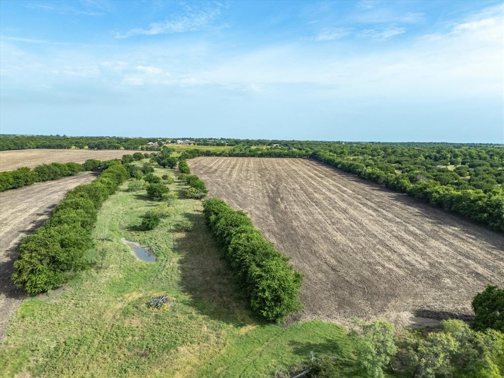 3506 County Road 1106 Rio Vista, TX 76093 - Photo 2 of 40 Aerial view of sparsely populated area with rows of crops