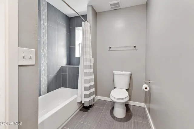 a white toilet sitting next to a white tub