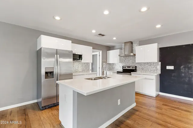 a kitchen with a sink a counter top space stainless steel appliances and cabinets