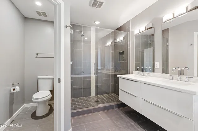 a bathroom with a sink a toilet and shower