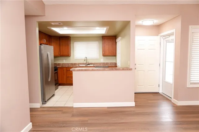a view of kitchen with stainless steel appliances granite countertop a stove a sink and a refrigerator