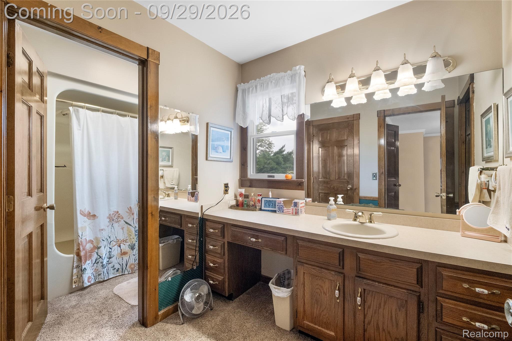6411 Farrand Road Clio, MI 48420 - Photo 18 of 33 Extended wood-finish vanity with an integrated sink, polished chrome faucet, and a wall-mounted light fixture with five white glass shades