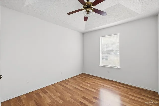 an empty room with windows and fan