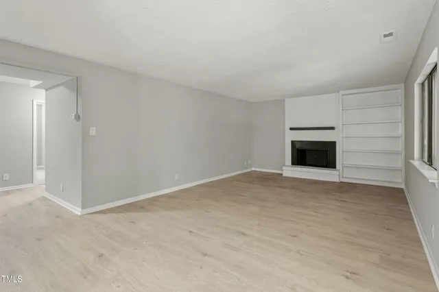 a view of empty room with a fireplace