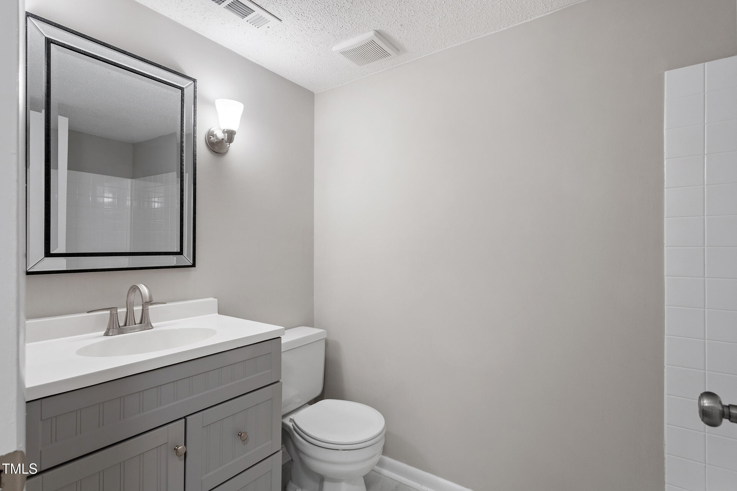 3088 Colony Road, Unit A Durham, NC 27705 - Photo 7 of 24 a bathroom with a toilet a sink and mirror