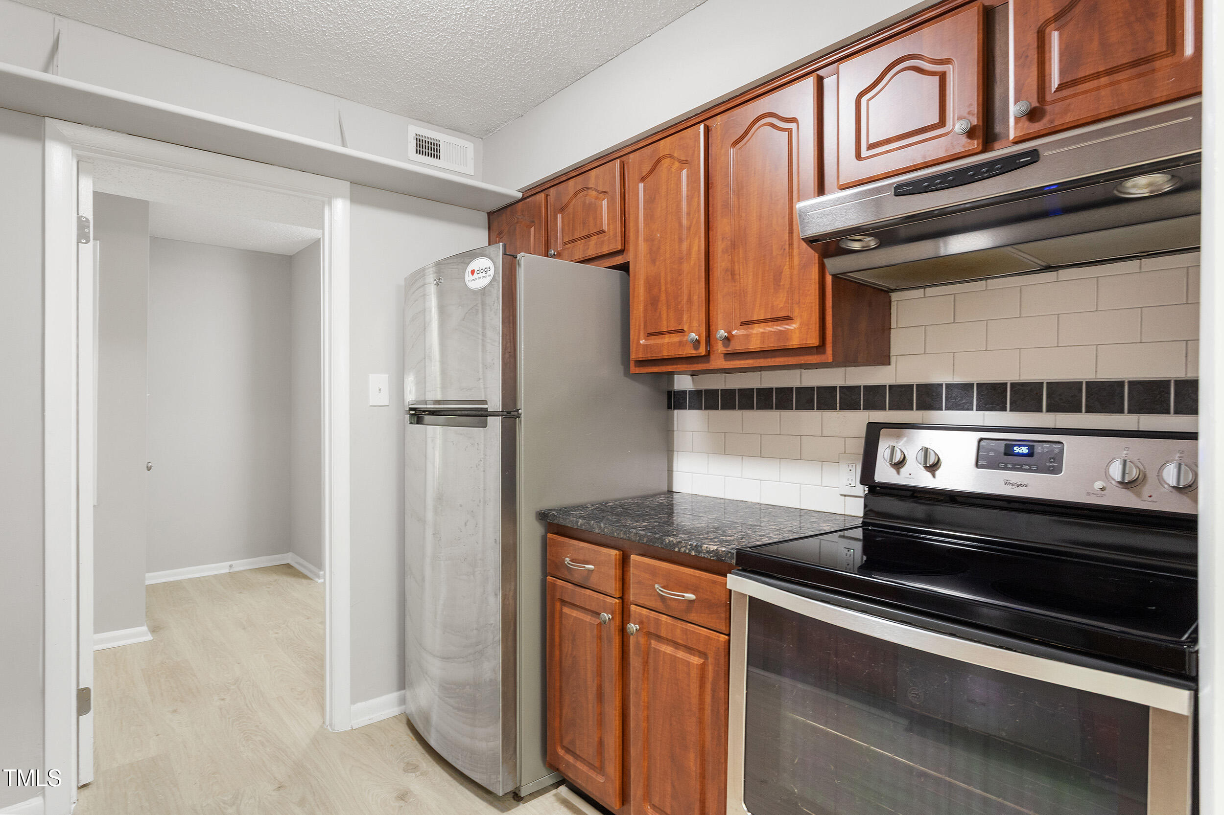3088 Colony Road, Unit A Durham, NC 27705 - Photo 8 of 24 a kitchen with stainless steel appliances granite countertop a refrigerator and a stove top oven