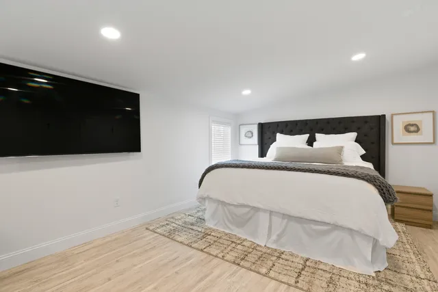 a bathroom with a granite countertop sink a large mirror a toilet and a window