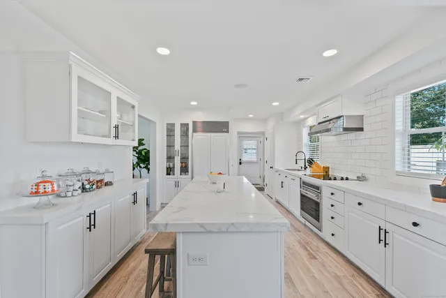 a kitchen with counter top space a sink wooden floor and cabinets