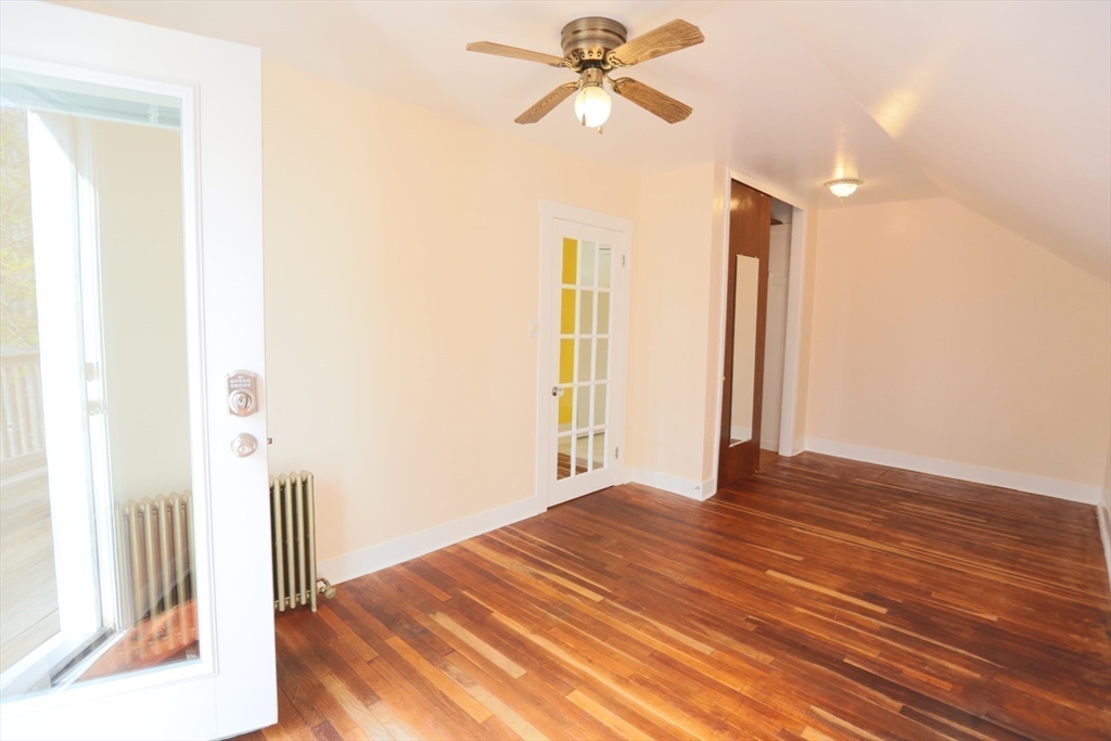 134 Baldwin Street, Unit 2 Fall River, MA 02720 - Photo 8 of 30 a view of a livingroom with wooden floor and a ceiling fan