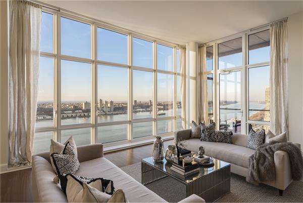 a living room with furniture and floor to ceiling windows