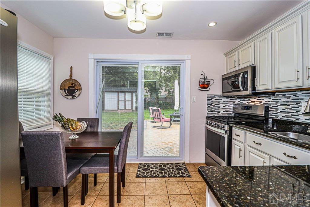 90 Ashley Road Edison, NJ 08817 - Photo 13 of 32 a kitchen with stainless steel appliances granite countertop a stove a sink and a microwave