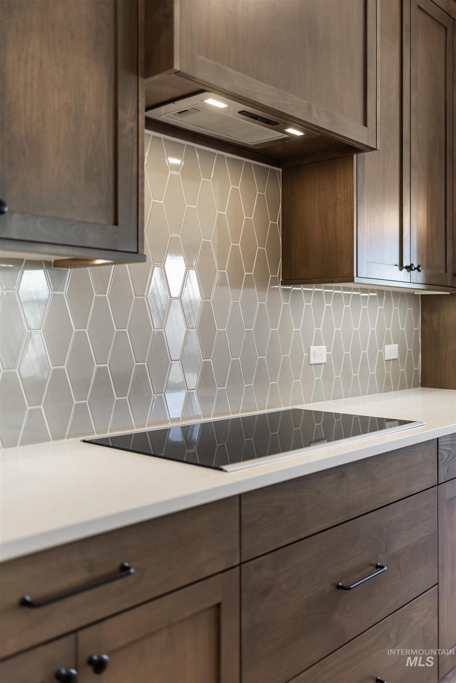400 South Diesel Way Boise, ID 83716 - Photo 13 of 44 Kitchen featuring decorative backsplash, black electric stovetop, dark wood finish cabinets, and light stone counters