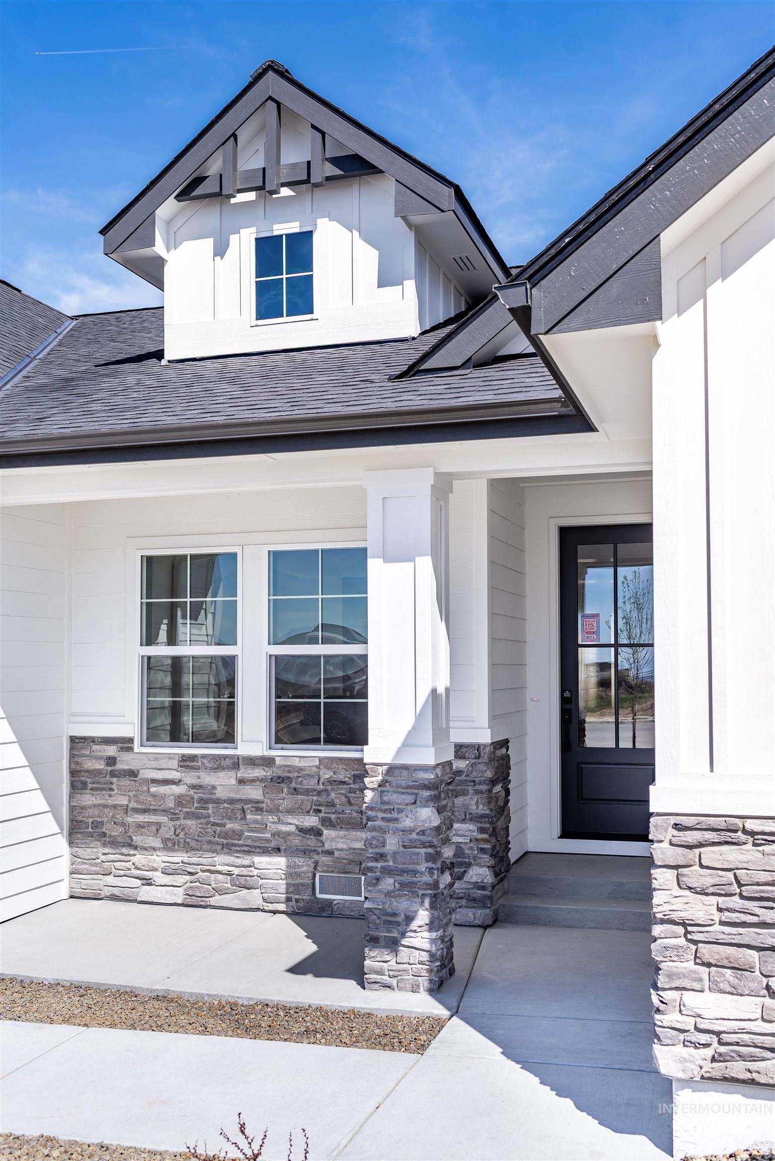 400 South Diesel Way Boise, ID 83716 - Photo 2 of 44 View of exterior entry with a shingled roof, stone siding, a porch, and board and batten siding