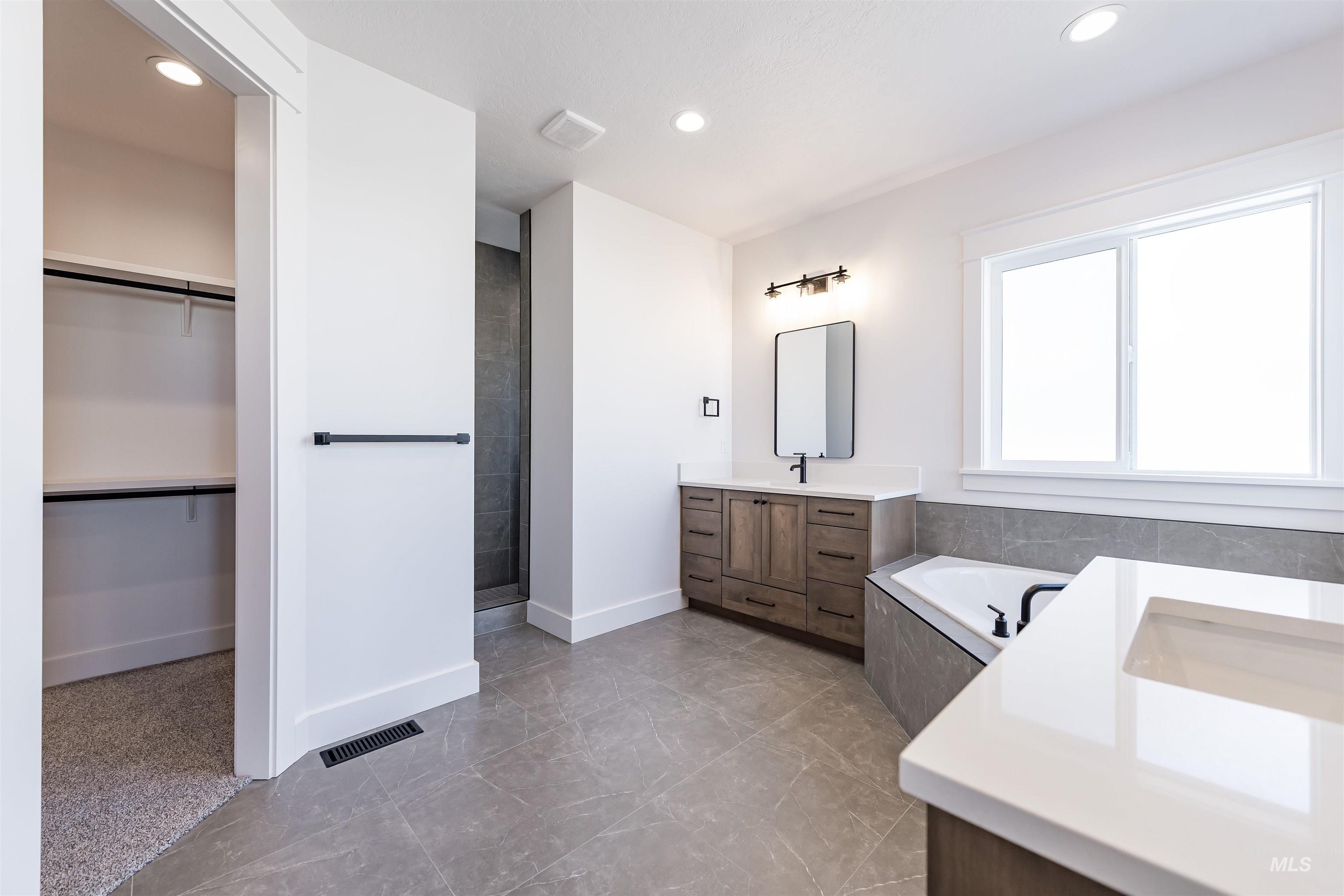 400 South Diesel Way Boise, ID 83716 - Photo 19 of 44 Full bath with two vanities, a garden tub, recessed lighting, a walk in closet, and a tile shower