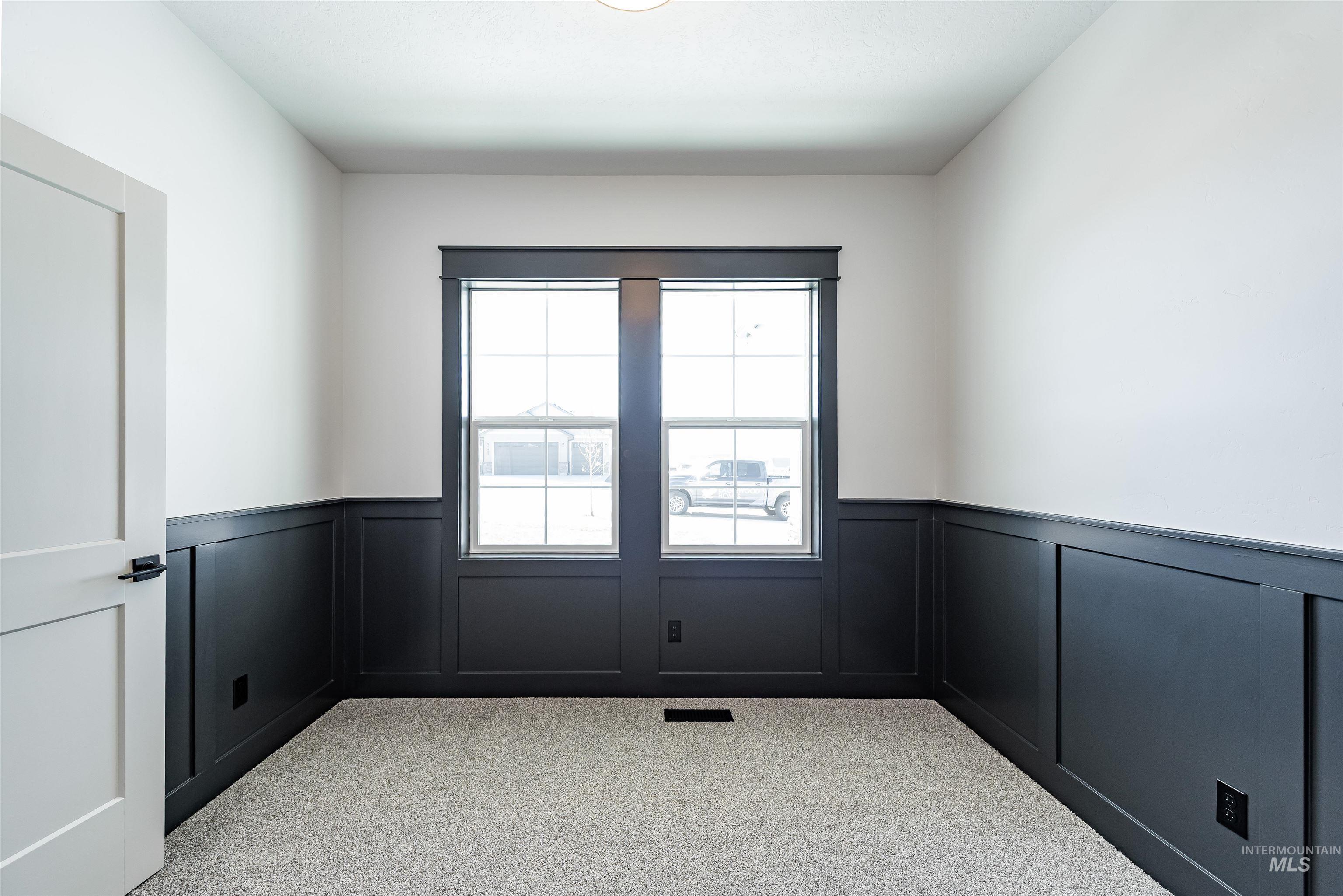 400 South Diesel Way Boise, ID 83716 - Photo 34 of 44 Empty room featuring light colored carpet, wainscoting, and a decorative wall