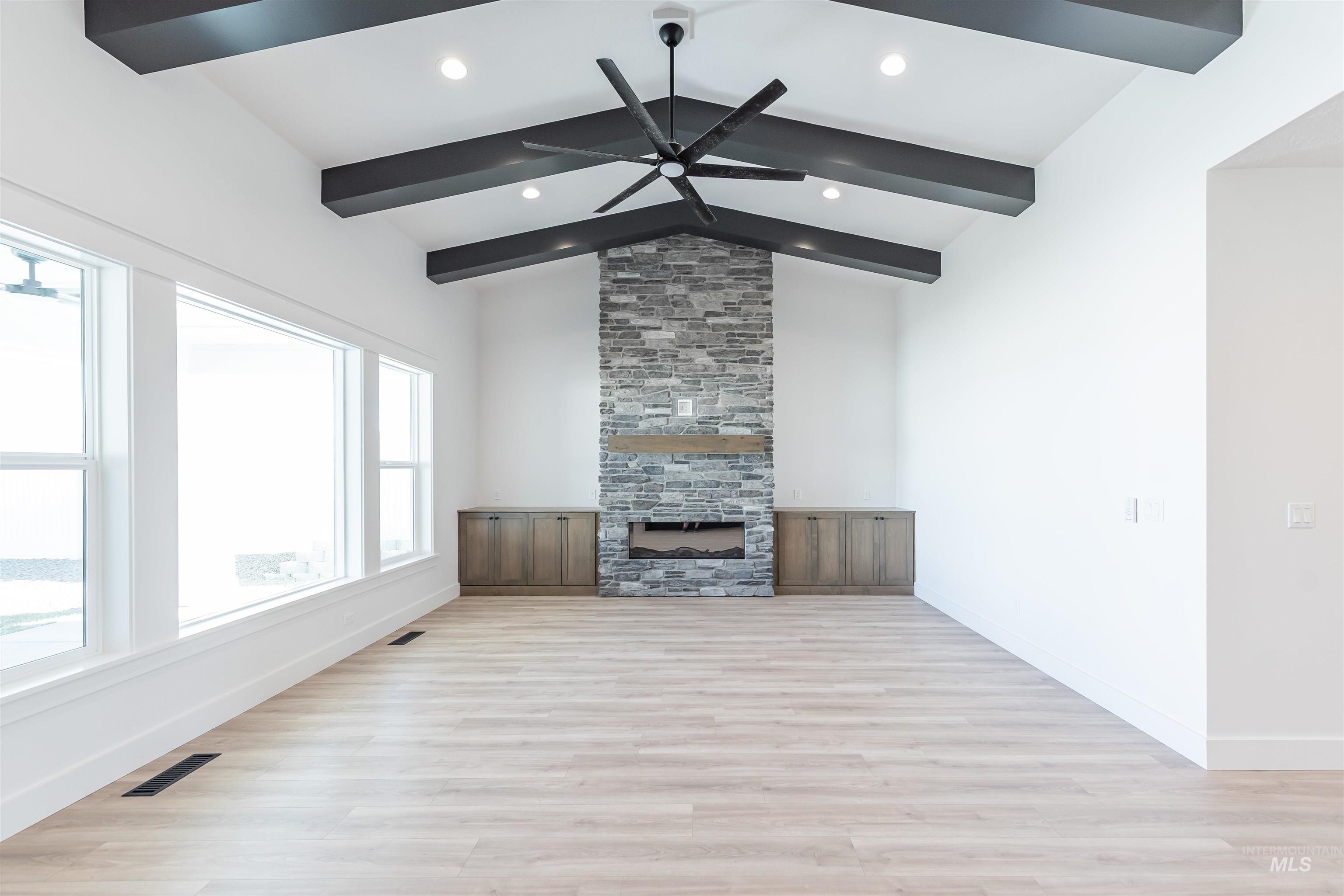 400 South Diesel Way Boise, ID 83716 - Photo 6 of 44 Unfurnished living room featuring light wood-type flooring, ceiling fan, a large fireplace, and lofted ceiling