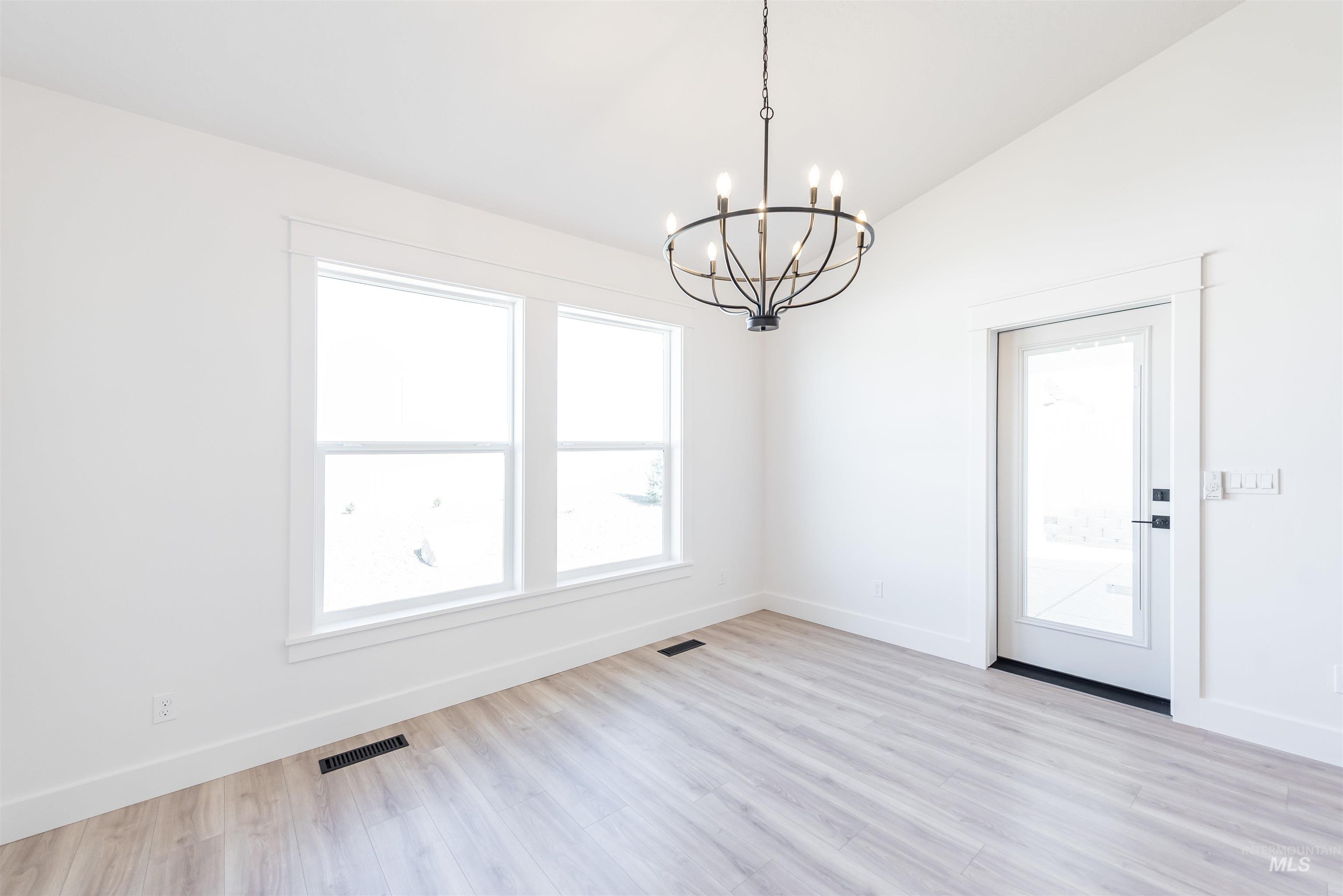 400 South Diesel Way Boise, ID 83716 - Photo 9 of 44 Unfurnished dining area with suspended lighting, vaulted ceiling, and light wood-style floors