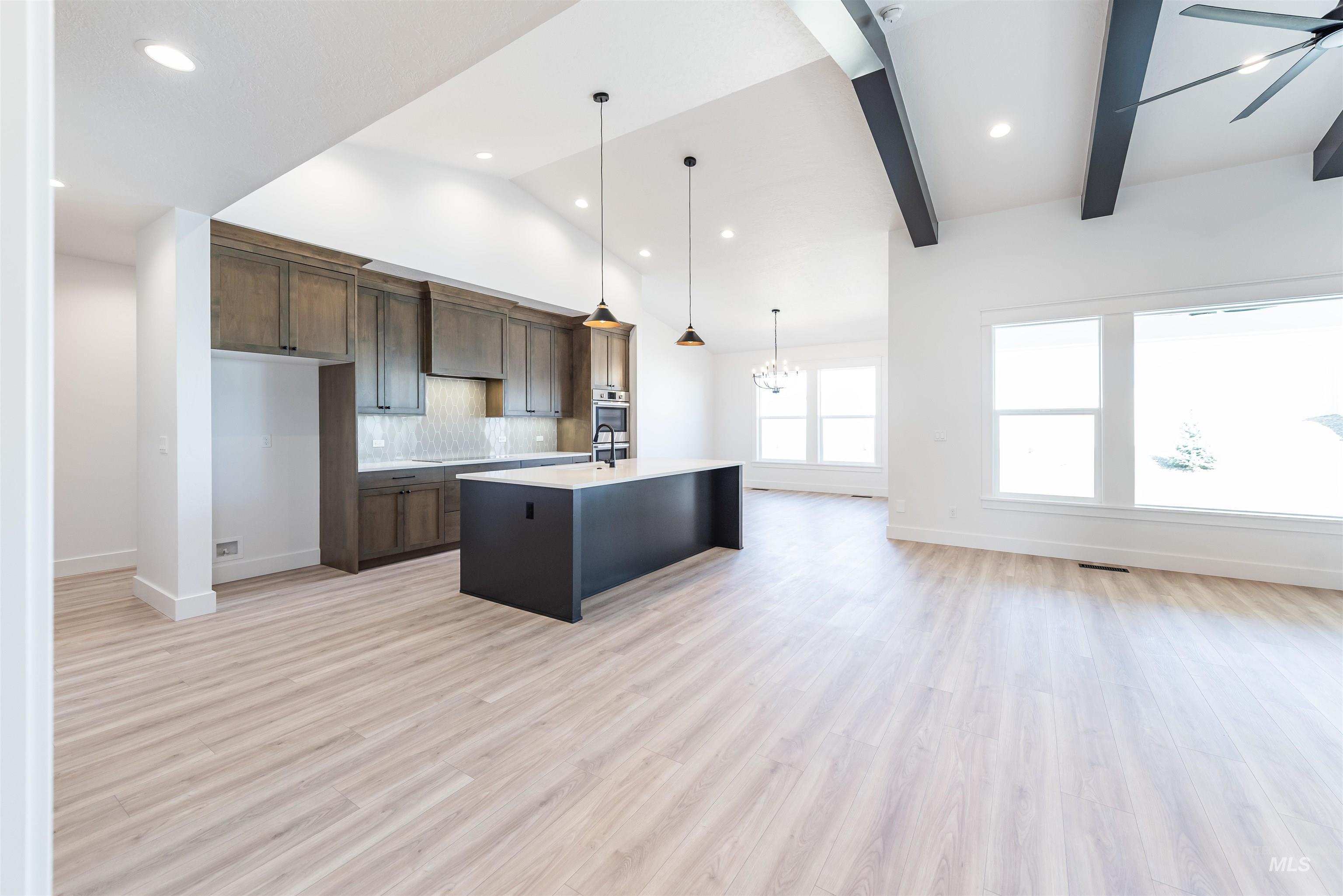 400 South Diesel Way Boise, ID 83716 - Photo 43 of 44 Kitchen featuring open floor plan, tasteful backsplash, an island with sink, light wood-style floors, and lofted ceiling