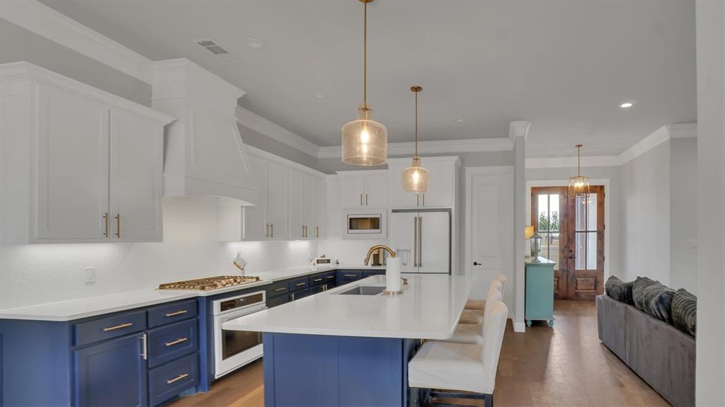101 Sky Way New Fairview, TX 76078 - Photo 3 of 20 a kitchen with granite countertop a stove a sink a refrigerator a living room dining table and chairs