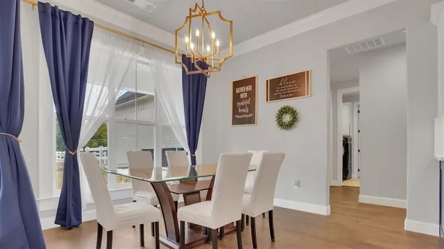 a view of a dining room with furniture wooden floor and chandelier