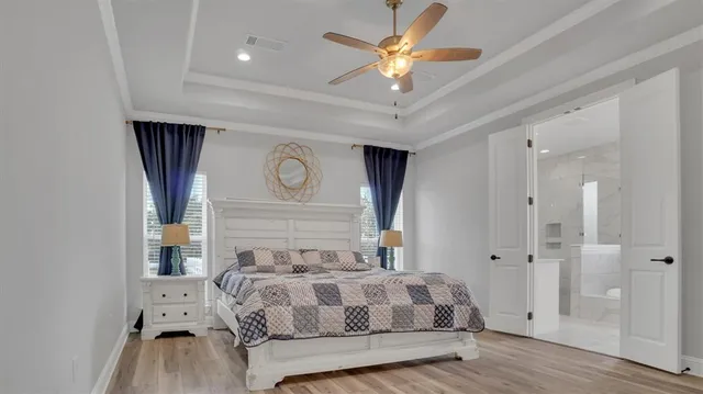 a bedroom with a large bed and a chandelier
