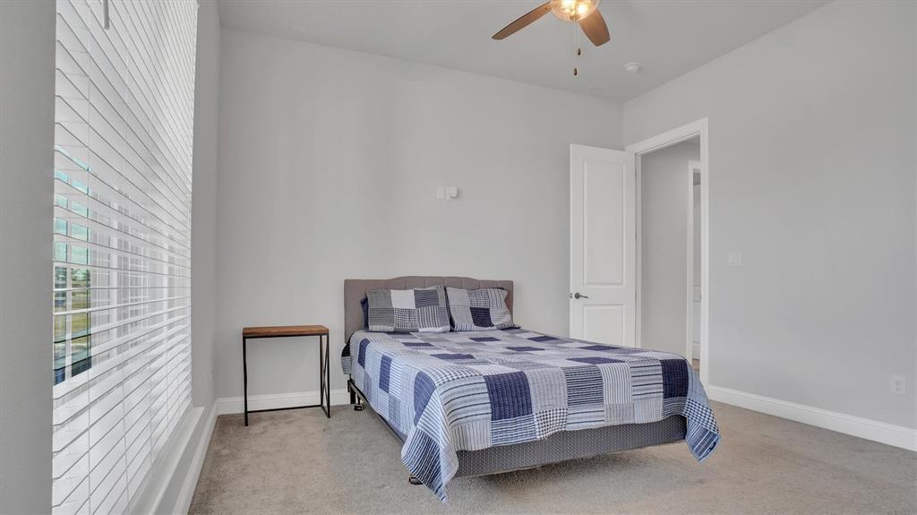 101 Sky Way New Fairview, TX 76078 - Photo 8 of 20 a bedroom with a large bed and a chandelier