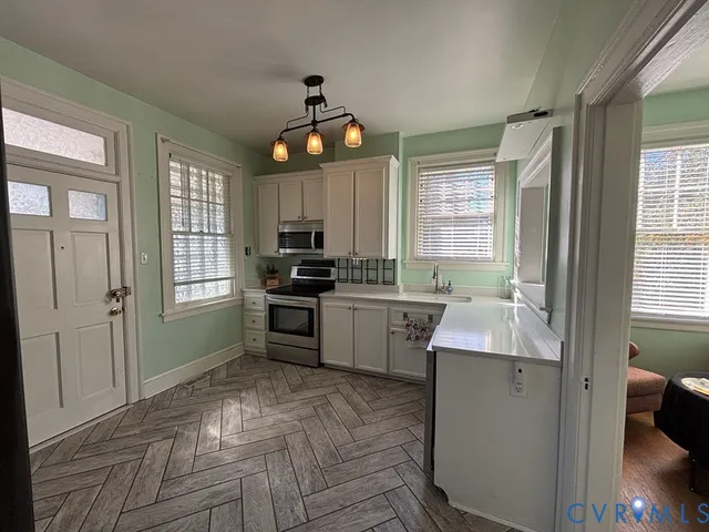 a kitchen with granite countertop a stove a sink a window and stainless steel appliances