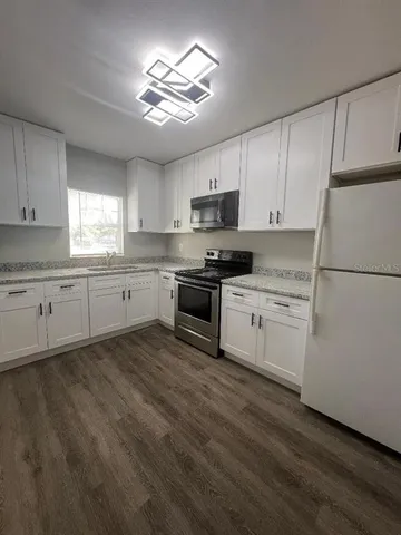 a kitchen with granite countertop white cabinets and white appliances