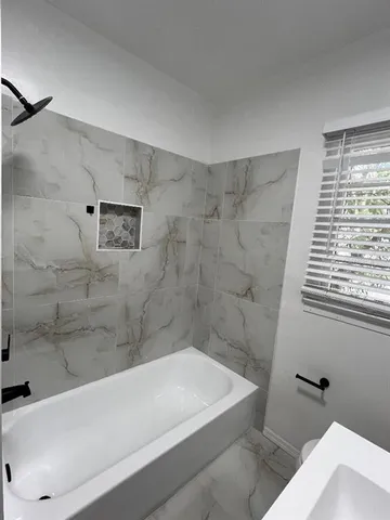 a bathroom with a bathtub and shower