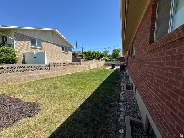 1611 South 75 East Bountiful, UT 84010 - Photo 5 of 6 Expansive side yard featuring a manicured lawn area and a decorative concrete block privacy wall